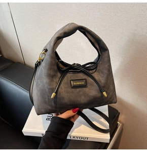 Detail of grey denim texture bag with gold hardware and stylish black bow decoration