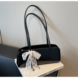 Schwarze glänzende Achseltasche Detail mit weißer Spitzenblume und doppelten Trägern