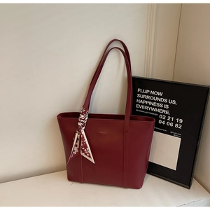Detailansicht der weinroten Shopper-Tasche mit Seidenschal und goldener Prägung