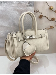 Elegante borsa a mano in pelle crema con grana litchi e ciondolo a cuore in un set raffinato
