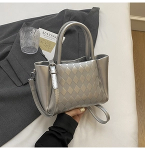 Detail of silver quilted bucket bag with metallic faux leather and embossed rhombic pattern