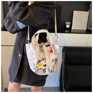 Detail of white canvas bucket bag featuring red graffiti text and heart pattern design
