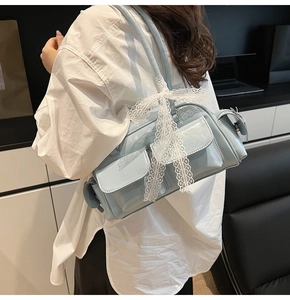Detail view of light blue patent leather Boston bag with lace bows on shoulder