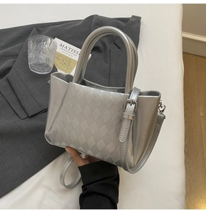 Close-up of silver metallic bucket bag with quilted texture and adjustable strap