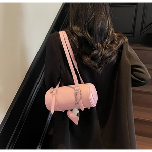Pink cilinder handbag in oil wax leather with heart charm on a black blazer outfit