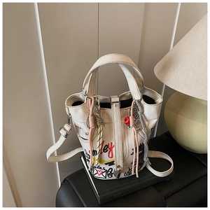 Detail of white canvas bucket bag with colorful graffiti art and red heart patterns