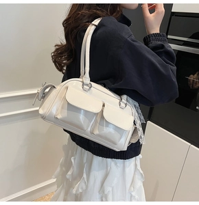 Detail of cream white Boston bag featuring dual magnetic flap pockets and glossy finish