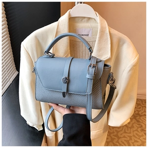 Détail du sac bleu brume en cuir et tissage avec fermoir métallique circulaire chic