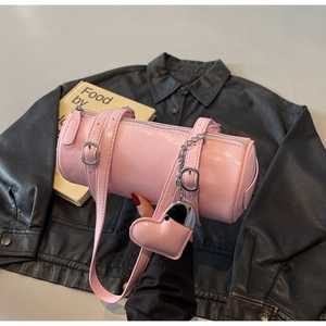 Pink cylindrical crossbody bag featuring a silver metal chain and heart-shaped pendant