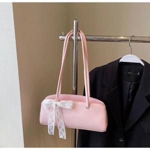 Detail of pink shoulder bag with lace bow decoration and smooth leather texture