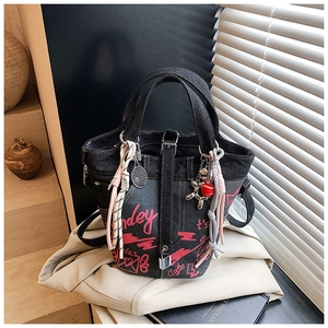 Detail of dark denim bucket bag with street graffiti prints and metal padlock