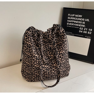 Détail d'un sac cabas en toile à motif léopard avec fermeture à cordon et longues anses
