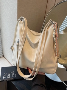 Borsa tote minimalista in pelle cerata beige con corda intrecciata tenuta in mano