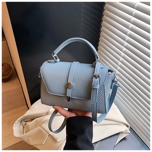 Vue détaillée du sac bleu clair montrant la texture du cuir et le fermoir métallique