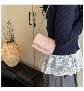 Detailed view of pink chain crossbody bag with textured leather and silver metal strap