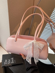Pink baguette shoulder bag with a white lace bow detail and dual slim straps
