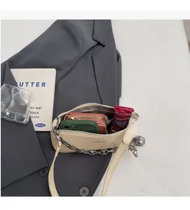 Vue intérieure du sac à bandoulière beige brillant montrant l'espace pour téléphone et portefeuille
