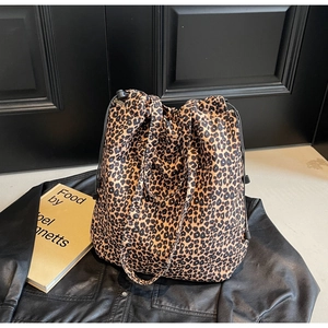 Détail du sac cabas en nylon à imprimé léopard avec fermeture à cordon et bandoulière noire