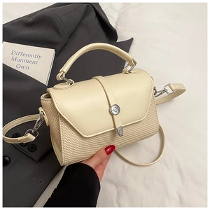 Détail montrant la texture du cuir et du tissu tissé de ce sac à bandoulière chic