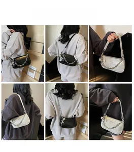 Collage de sacs sous les aisselles en noir et beige avec chaînes et breloques chien