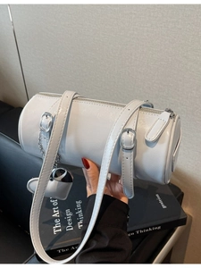Minimalist white leather barrel bag with heart charm pendant and slender handles
