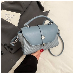 Détail du sac à bandoulière bleu en similicuir avec texture tissée et boucle argent