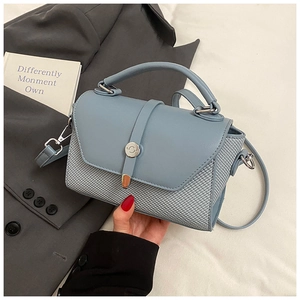 Vue détaillée du sac bandoulière bleu clair avec texture tissée et boucle en métal