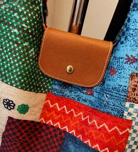Detail van de meerkleurige patchwork canvas shopper met bruine leren klep en gouden knop