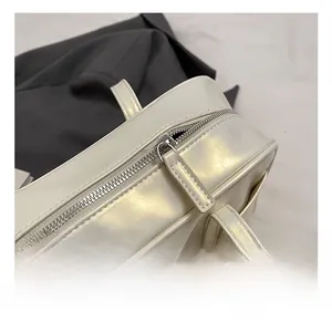 Detail of silver metal zipper and glossy beige synthetic leather on minimalist tote bag