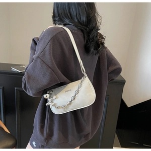 Détail du sac bandoulière gris avec grosse chaîne en métal et breloque chien ballon argenté