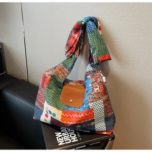 Detail van bohemien patchwork hobo tas met lederen flap en geknoopte strikhendel