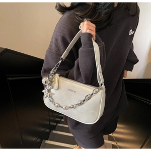 Détail du sac bandoulière argenté métallisé avec chaîne épaisse et logo de la marque