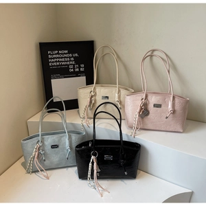 Detail of trendy tote bags in four colors with bear embossed patterns and knot charms