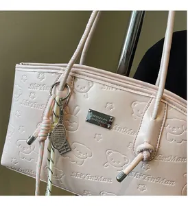 Detail of pink faux leather tote bag with cute animal embossing and premium metal hardware