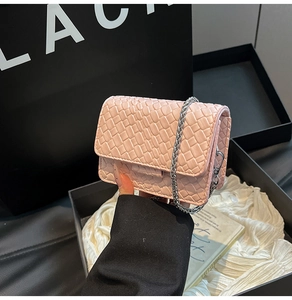 Close-up of pink woven leather mini flap bag with metallic chain strap detail