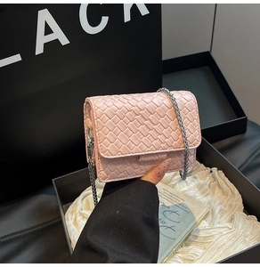 Detailed close-up of pink woven crossbody bag with elegant silver chain strap and flap