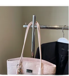 Detail of light pink tote bag with embossed cartoon bear and floral patterns on leather