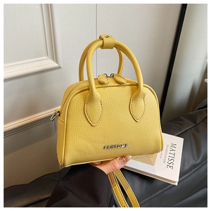 Detail of yellow lychee texture leather mini Boston bag with silver metal logo branding