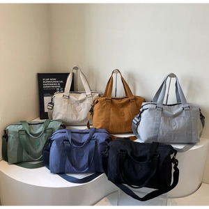 Detail view of large travel tote bags in six colors with woven handles and logos