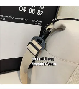 Detalle de correa ajustable con ganchos de plástico negro en bolso de viaje beige