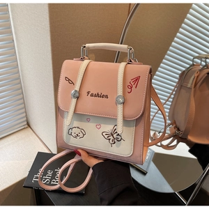 Detail eines Mini-Rucksacks im Color-Block-Design mit Hundestickerei und Metalldetails