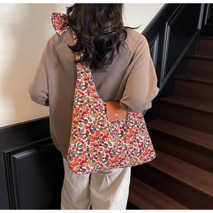 Bloemen canvas draagtas met bruine lederen flap en magneetsluiting op de schouder