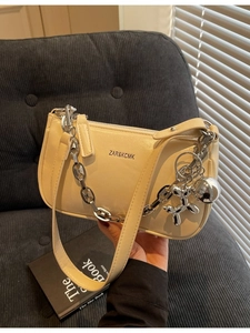Sac à bandoulière crème en cuir brillant avec chaîne argentée et breloque chien