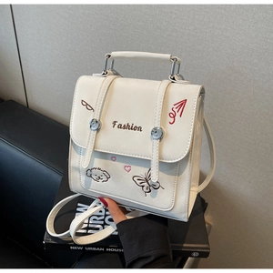 Detail des weißen Lederrucksacks mit Blumen- und Hundestickerei sowie Metallschnalle