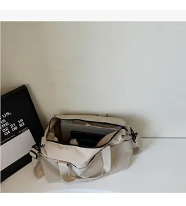 Detalle del amplio compartimento interior del bolso de viaje de lona beige con cremallera negra