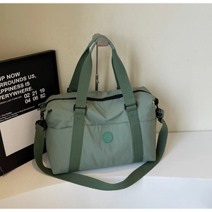 Detail of mint green travel tote showing durable nylon texture and round logo badge