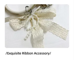 Close-up of elegant cream lace bow charm with white pearls on a leather handbag