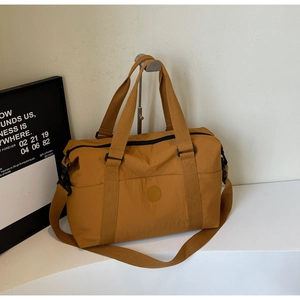 Close-up of mustard yellow travel tote bag with nylon fabric and adjustable strap