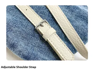 Dettaglio della tracolla regolabile in pelle crema sulla borsa a secchiello in denim blu
