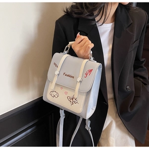 Detail des zweifarbigen Rucksacks mit Fashion-Text und süßer Cartoon-Stickerei
